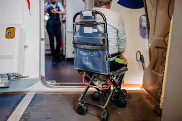 Rear view of man on special wheelchair for transport in the airplane. Concept of traveling with special needs.