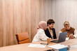© Drobot Dean - Group of female colleagues working on laptop and using mobile phone during meeting in conference room