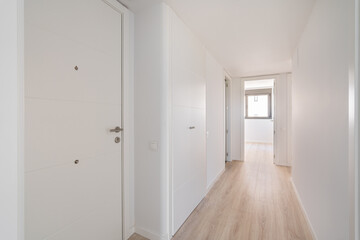 narrow white corridor with doors and entrances to different rooms and premises and resting on a room