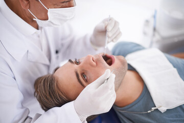 Wall Mural - At the dentist for his bi-annual checkup. a young man at the dentist.