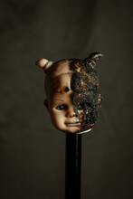 Damaged Dirty Burnt Doll Head On Grey Background