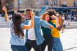 © unai - Multi ethnic young friends dancing in a city square, group of diverse friends having fun