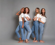 © gpointstudio - Full length of four young caucasian women wearing blue jeans and white tshirt on grey background