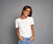 © gpointstudio - Portrait of young caucasian woman wearing blue jeans and white tshirt on grey background