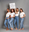© gpointstudio - Four young caucasian women wearing white tshirt and holding banner above heads