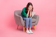© deagreez - Full length photo of crying tired woman wear green shirt sitting couch arms close eyes isolated pink color background