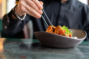 man hand eat chicken curry rice holding chopsticks