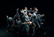 © master1305 - Group of young people in gray stage costumes making performance, dancing against black studio background. Concept of modern freestyle dance, contemporary art, movements, hobby and creative lifestyle