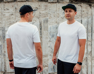 Wall Mural - Young guy wearing white blank t-shirt and black cap. Mock-up for print. T-shirt template. Back and front view