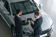 © standret - View from the top. Two businessmen are working together in the car showroom