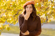 © Andrii Lysenko - Beautiful shocked woman walking outdoors in autumn, looking at camera covering her mouth with hand