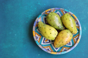 Canvas Print - Prickly pear cactus on a decorative blue plate. Bright blue background with copy space. Balanced diet concept. Natural antioxidant. Fruit of Israel. 