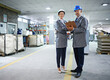We get every job done to spec. Portrait of two managers standing inside a printing and packaging plant.