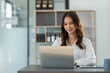 © crizzystudio - Beautiful Asian businesswoman working on a laptop computer doing financial, accounting analysis, reports, and data at the office.