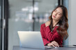 © crizzystudio - Asian businesswoman sitting in office stressed and fatigued from overwork on financial matters on office desk.