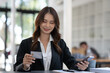 © crizzystudio - Asian businesswoman thinking and making a decision Shop online with a credit card in the office.