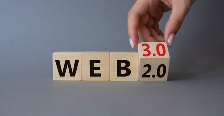 Web 3.0 vs Web 2.0 symbol. Hand turns cubes and changes the word web 2.0 to web 3.0. Beautiful grey background. Businessman hand. Business concept. Copy space