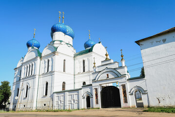 white orthodox church with blue domes on a sunny summer day