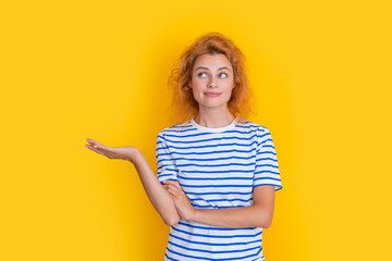 redhead woman portrait presenting product isolated on yellow background. portrait of woman