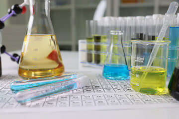 Wall Mural - Research laboratory glassware with reagents on periodic table of chemical elements.