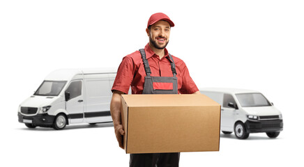 Wall Mural - Worker in a uniform holding a cardboard box and standing in front of vans