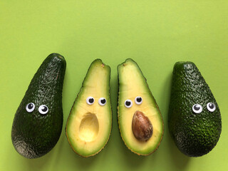 Avocados with googly eyes, whole and cut in half