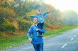 © Kostia - A Happy parent with child are walking along the road in the park on nature travel