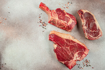 Wall Mural - Variety of Raw Black Angus Prime meat steaks T-bone, tomahawk, New York steak. Set raw marbled beef strip loin steaks. place for text, top view