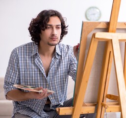 Wall Mural - Young handsome man enjoying painting at home