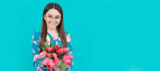 Poster - happy child in glasses with tulips. mothers or womens day. kid hold flowers. Banner of spring child girl with tulips flowers bouquet, studio portrait with copy space.