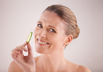 Wall Mural - Natural and fresh. Cropped portrait of a beautiful mature woman posing with a piece of cucumber.