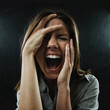 © Jeff B/peopleimages.com - Feeling the affects and agony of her confused and oppressed mind. A young woman screaming uncontrollably while isolated on a black background.