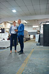 Poster - Catching up on the factory progress. two colleagues working together in a printing factory.