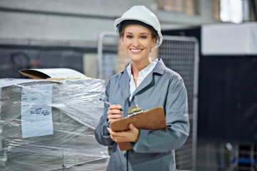 Poster - Feeling good about my job. A woman wearing a hardhat smiling at the camera in a factory.