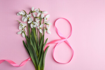 Wall Mural - Beautiful snowdrops and number 8 made of ribbon on pink background, flat lay