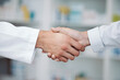 © Anela/peopleimages.com - Doctor, handshake and partnership in support at pharmacy for healthcare success, promotion or deal at clinic. Medical expert shaking hands in teamwork for life insurance, b2b or pharmaceutical needs