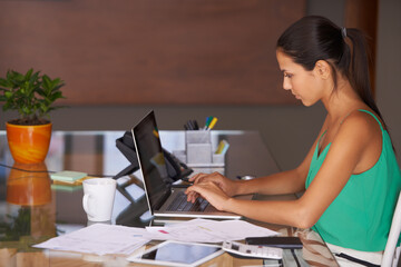 Poster - She learnt the value of hard work by working hard. A young woman hard at work sitting in her home office.