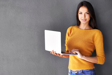 Sticker - I love my light-weight laptop. Portrait of an attractive young woman holding a laptop while standing against a gray wall.