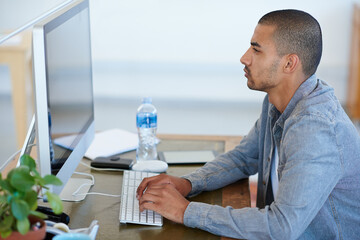 Sticker - One hundred percent focused. a handsome young man working at his computer in an office.