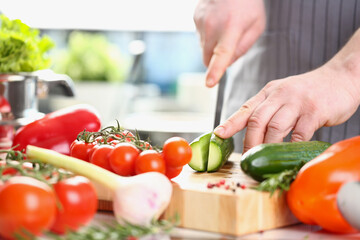 Wall Mural - Male chef preparing healthy vegetable salad with fresh organic ingredients