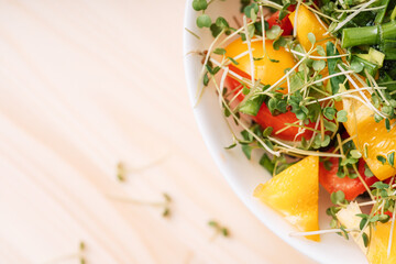 Wall Mural - Vegetable salad with microgreens on a wooden table.