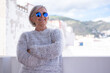 © luciano - Portrait of happy senior woman smiling and looking at city landscape. Face of attractive senior woman wearing blue reflective sunglasses outdoors. Relaxed retired woman with gray hair