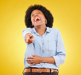 Poster - Pointing, laughing and fun with a black woman in studio on a yellow background enjoying a funny joke. Comic, comedy and laughter with an attractive young female feeling silly, goofy or playful