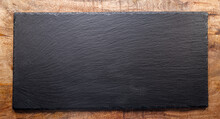 Natural Stone Black Slate Serving Plate On Wooden Background. Flat Lay.