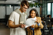 © AvokadoStudio - Happy black woman assistant with senior man CEO showing documents for market research idea