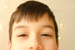 close up part male child's face, brown eyes of boy 10-12 years old looks into camera, concept eye health, vision examination, treatment of ophthalmic diseases, emotional development of children