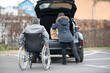 © Natalje Dietrich - A woman helps a disabled person on a wheelchair to pack groceries into the car