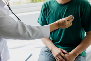 The doctor used a stethoscope to listen to the heartbeat of the man patient, medical checkup concept.