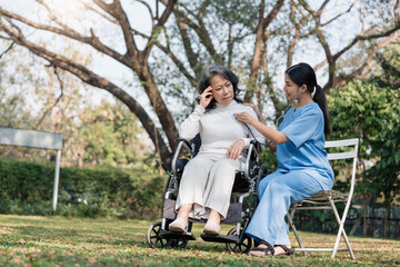 Wall Mural - Female nurse doing blood pressure measurement of a senior woman patient. Doctor checking blood pressure of an elderly woman at garden home. Female caregiver and senior woman together at home