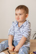 © Tina kids photo - cute baby boy is sitting drawing with pencils on the wooden floor of the house